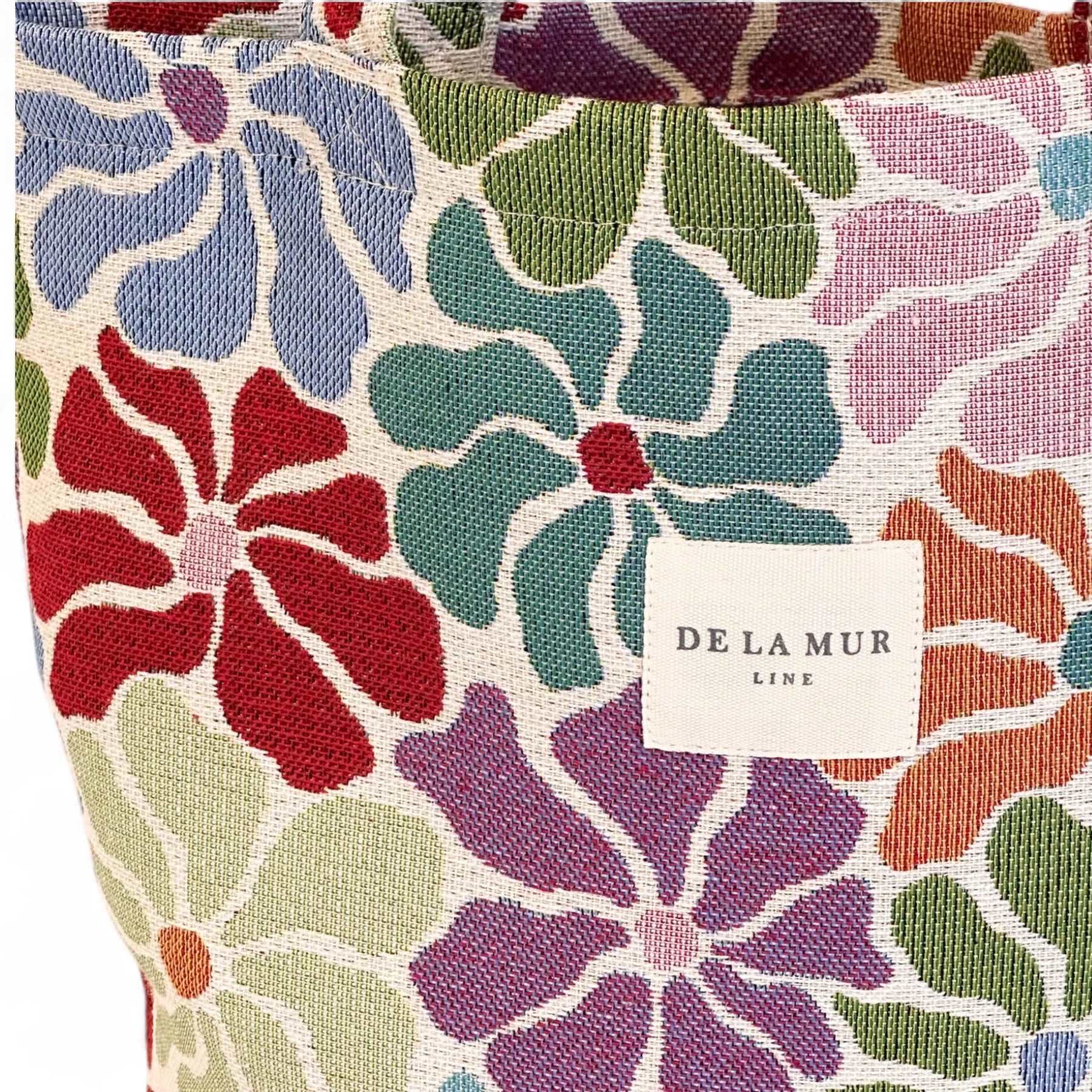 Detalle del estampado floral en tela gruesa de jacquard y etiqueta De La Mur Lime.