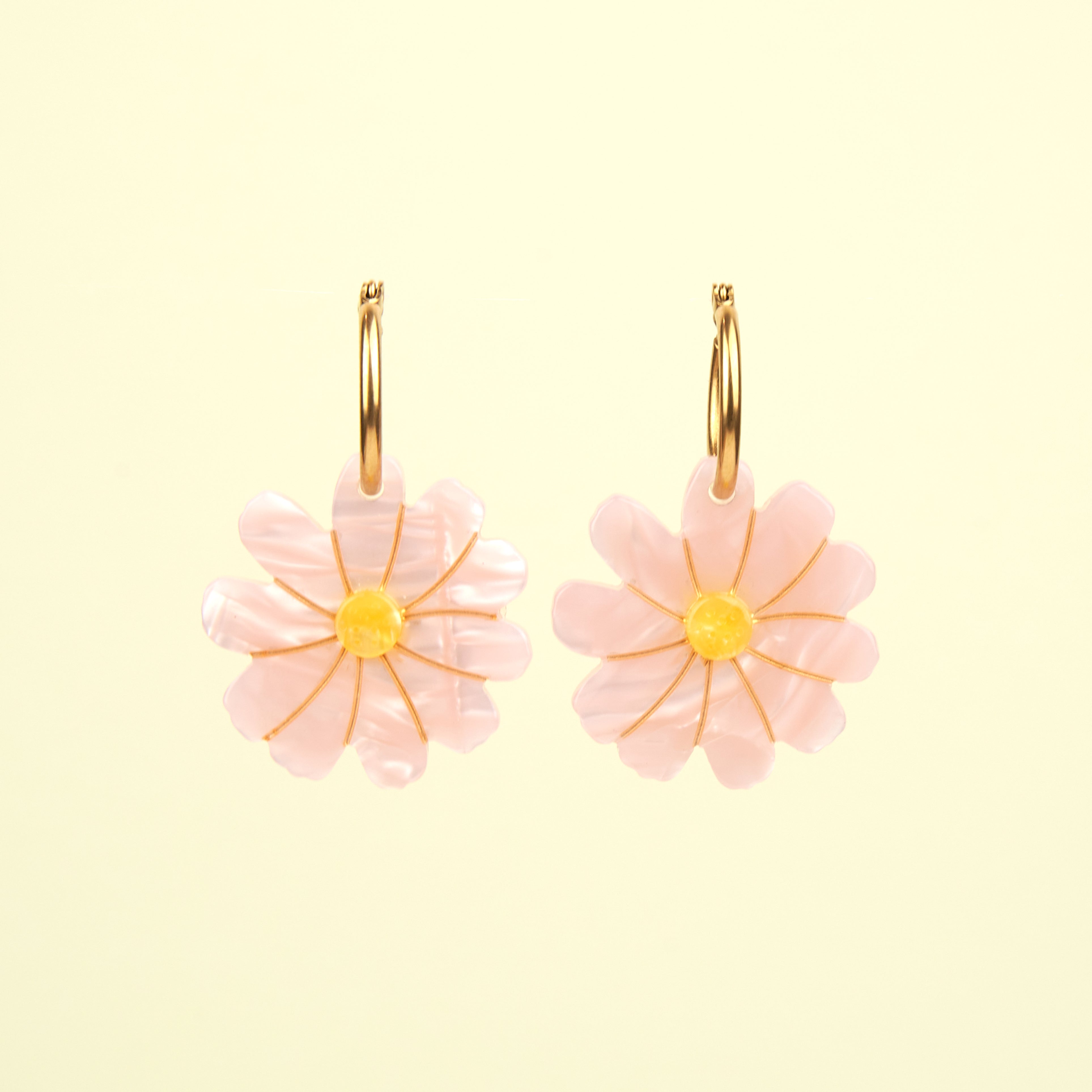 Par de pendientes flor Coucou Suzette en fondo amarillo, detalle de los pétalos.