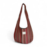 Bolsa ovalada de jacquard con rayas rojas, rosas y beige, vista frontal.