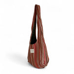 Bolsa ovalada con estampado de rayas en tonos cálidos, vista lateral.