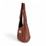 Bolsa ovalada con estampado de rayas en tonos cálidos, vista lateral.