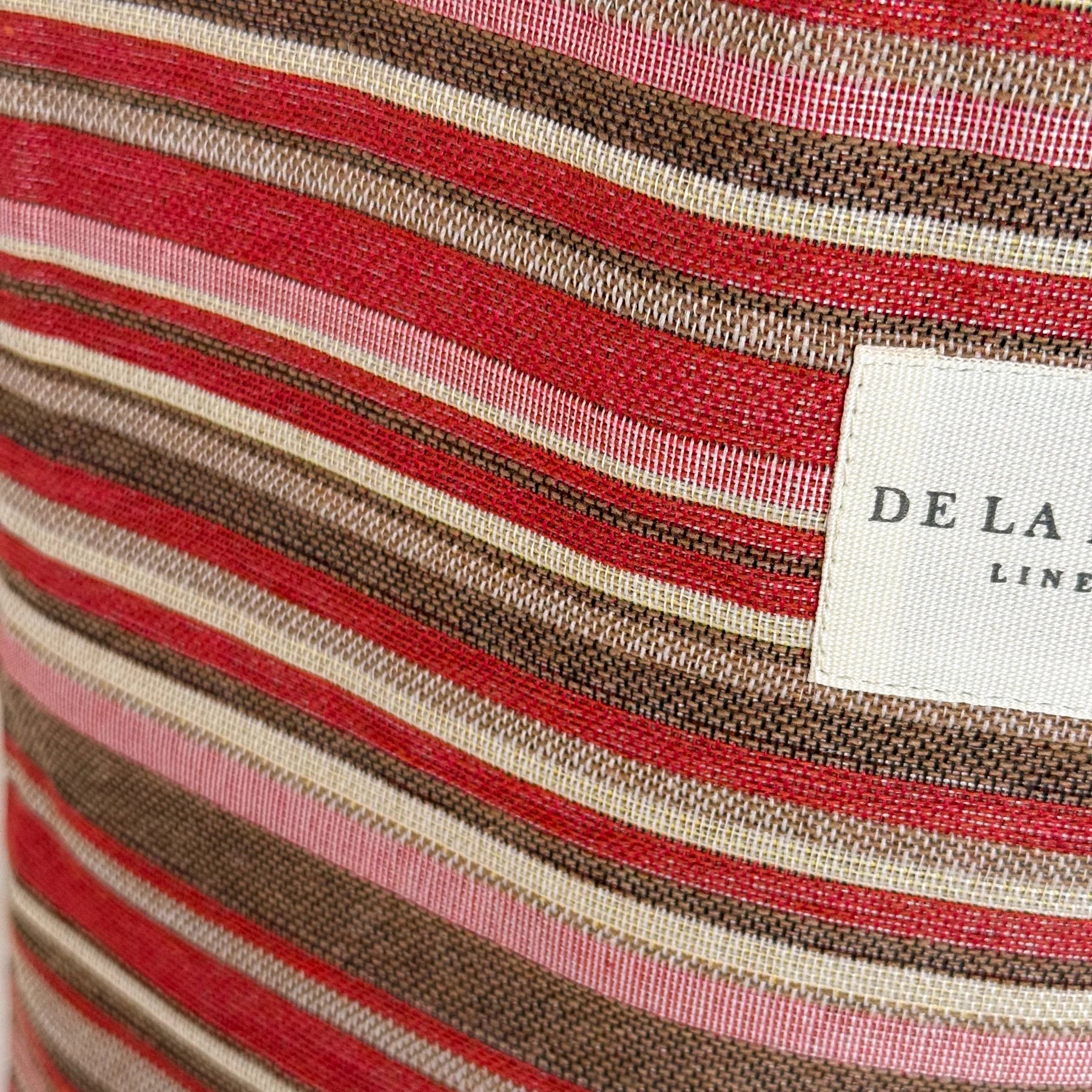 Detalle del tejido jacquard a rayas con etiqueta de la marca De La Mur.