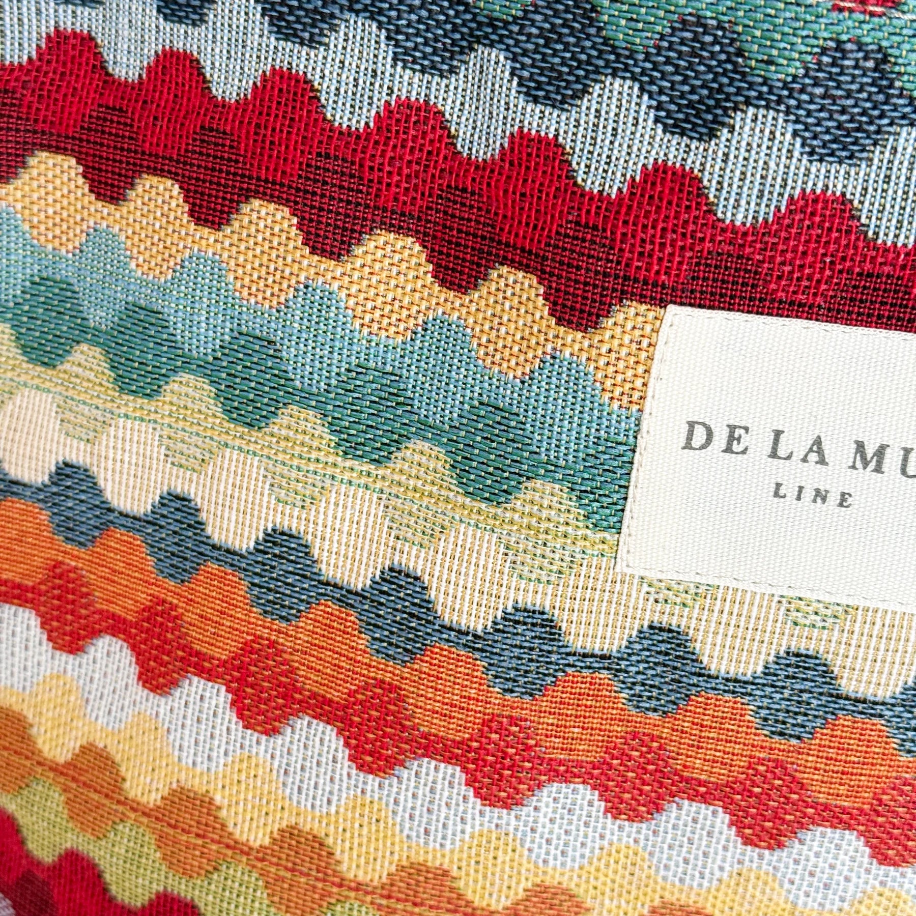 Detalle del tejido jacquard multicolor con etiqueta De La Mur.