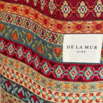 etalle del estampado geométrico multicolor y etiqueta De La Mur.