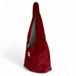 Bolsa ovalada de terciopelo granate, vista lateral mostrando su forma alargada.