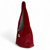 Bolsa ovalada de terciopelo granate, vista lateral mostrando su forma alargada.