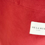 Detalle del tejido de terciopelo granate y etiqueta frontal de la marca De La Mur