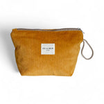 Neceser grande de pana mostaza con etiqueta De La Mur, vista frontal.