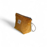 Neceser mostaza de pana con asa lateral de cordón beige, vista lateral.