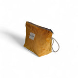 Neceser mostaza de pana con asa lateral de cordón beige, vista lateral.