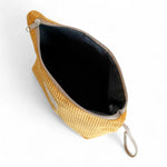 Interior del neceser grande de pana mostaza con forro gris.