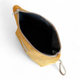 Interior del neceser grande de pana mostaza con forro gris.