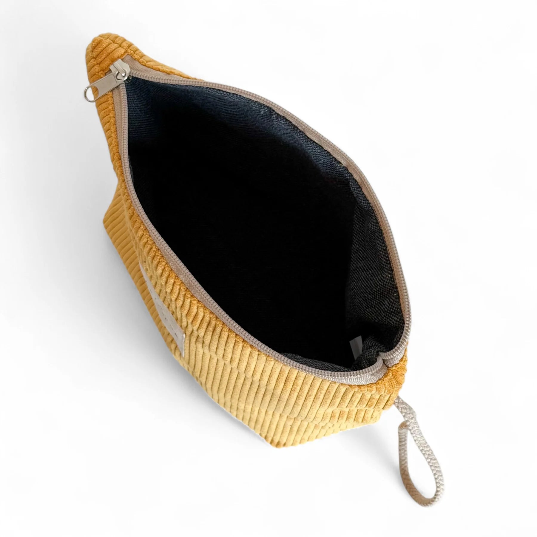 Interior del neceser grande de pana mostaza con forro gris.