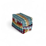 Neceser de estampado geométrico multicolor con cremallera y asa lateral, vista lateral.