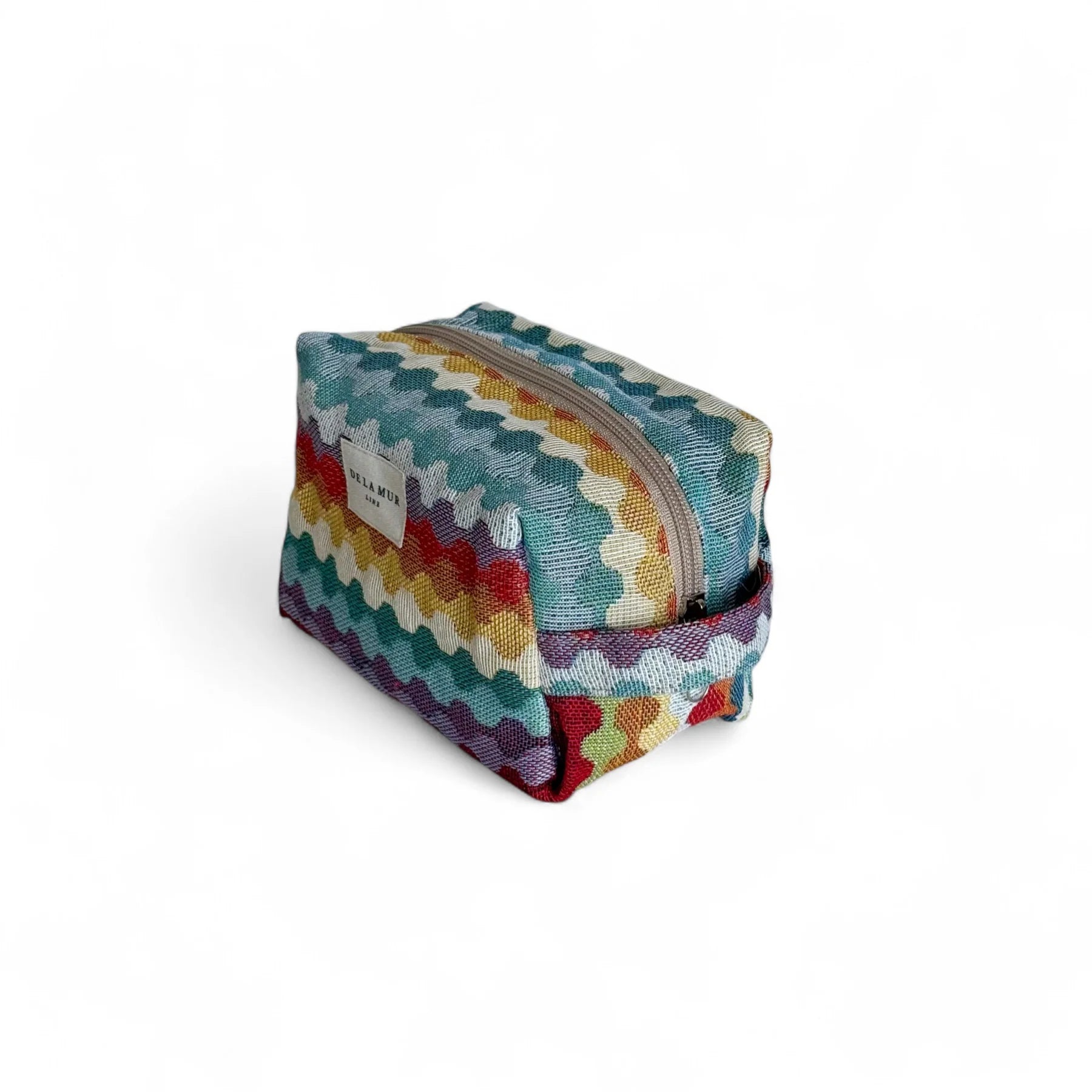 Neceser de estampado geométrico multicolor con cremallera y asa lateral, vista lateral.