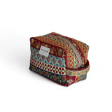 Neceser artesanal con estampado geométrico multicolor y asa lateral, vista lateral.