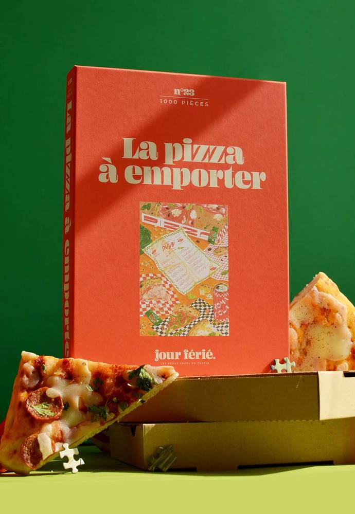 Caja roja del puzzle de 1000 piezas sobre cajas de pizza recicladas.
