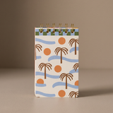 Bloc de notas Palm Beach con espiral dorada e ilustración de palmeras, olas y soles.