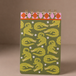 Bloc de notas Snake Garden con espiral dorada e ilustración de serpientes.