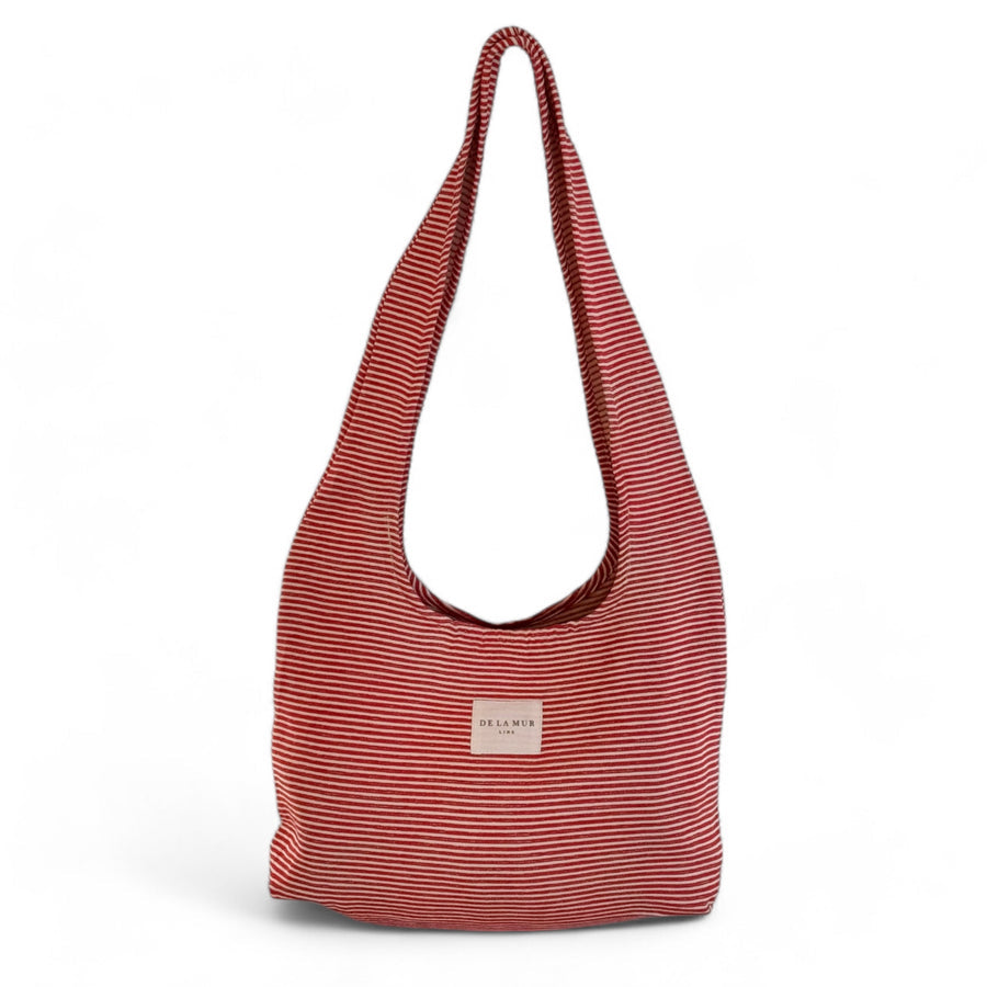 Bolsa ovalada con rayas rojas finas y asas largas, vista frontal.

