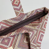 Detalle de la cremallera superior de la bolsa shopper grande de jacquard.