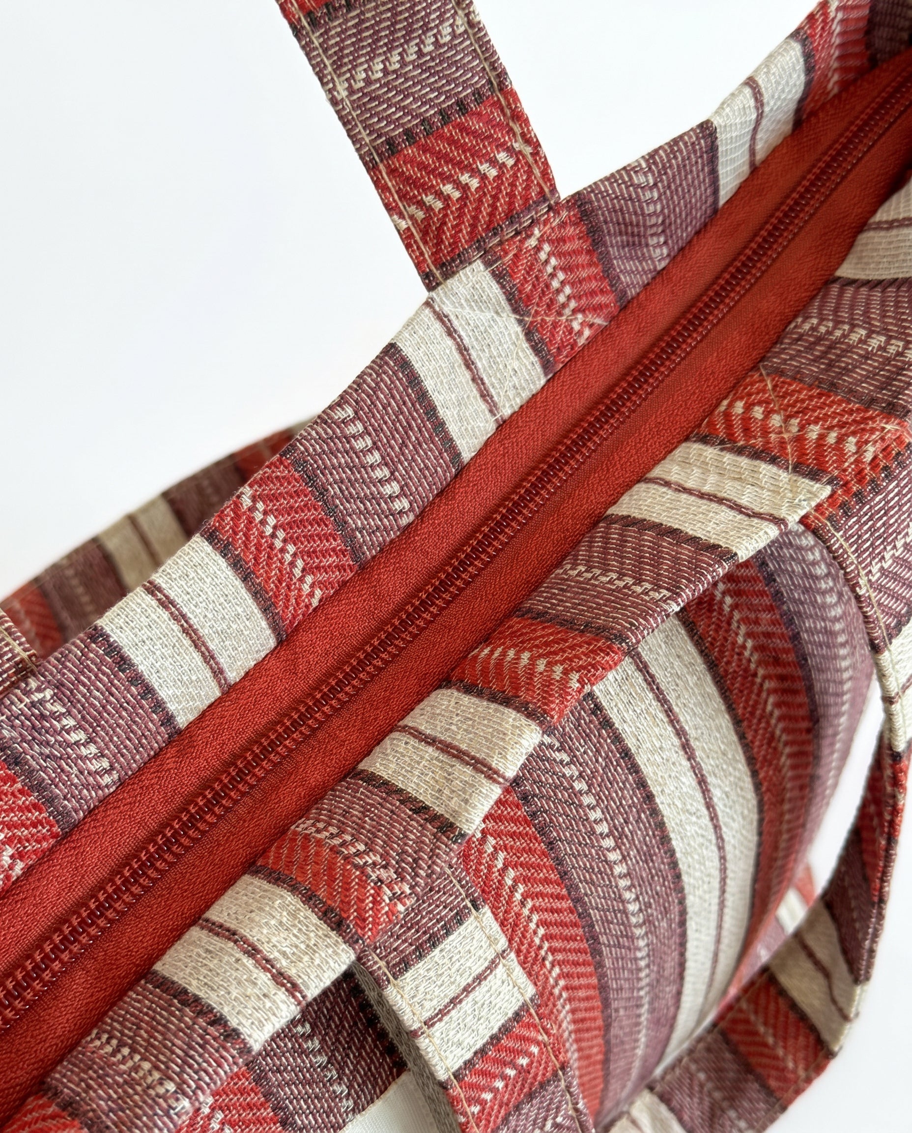 Detalle de la cremallera superior de la bolsa shopper de jacquard.