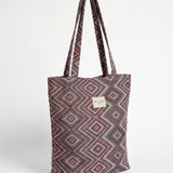Bolsa shopper de jacquard geométrica en tonos lila, rosa y granate.