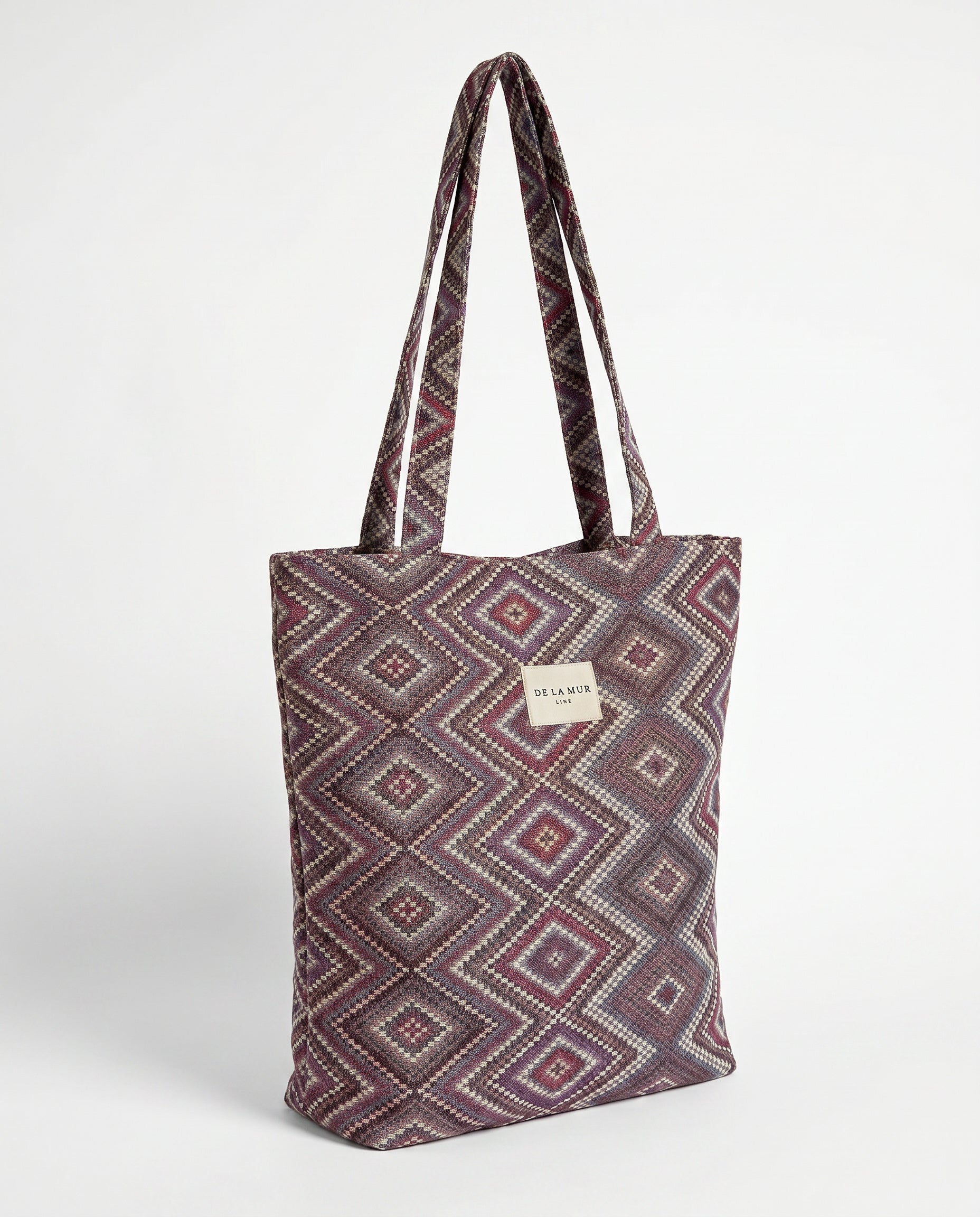 Bolsa shopper de jacquard geométrica en tonos lila, rosa y granate.