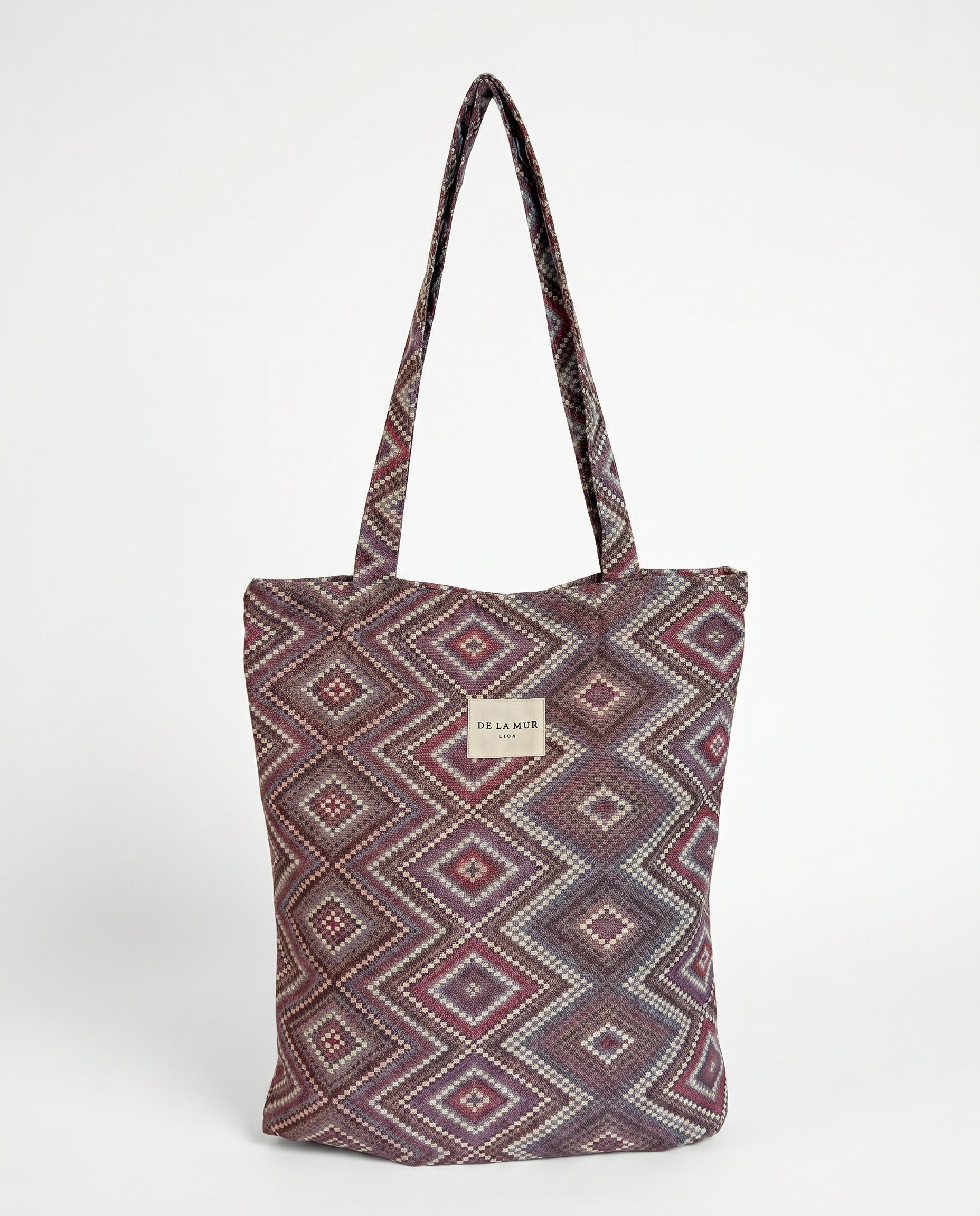 Bolsa shopper de jacquard con estampado geométrico en tonos lila y rosa, vista frontal.