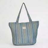 Bolsa shopper de jacquard de rayas azules llevada al hombro.
