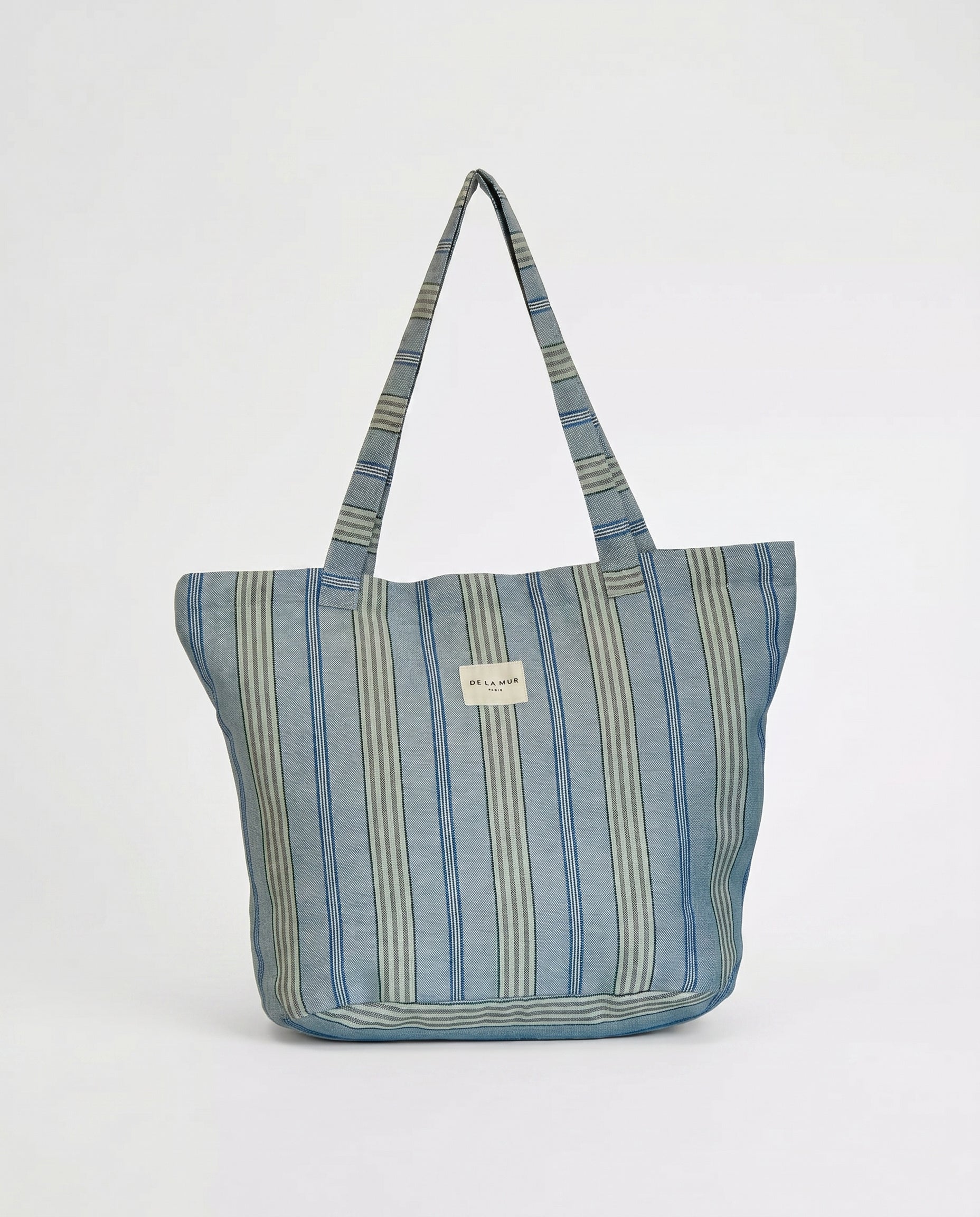Bolsa shopper de jacquard de rayas azules llevada al hombro.