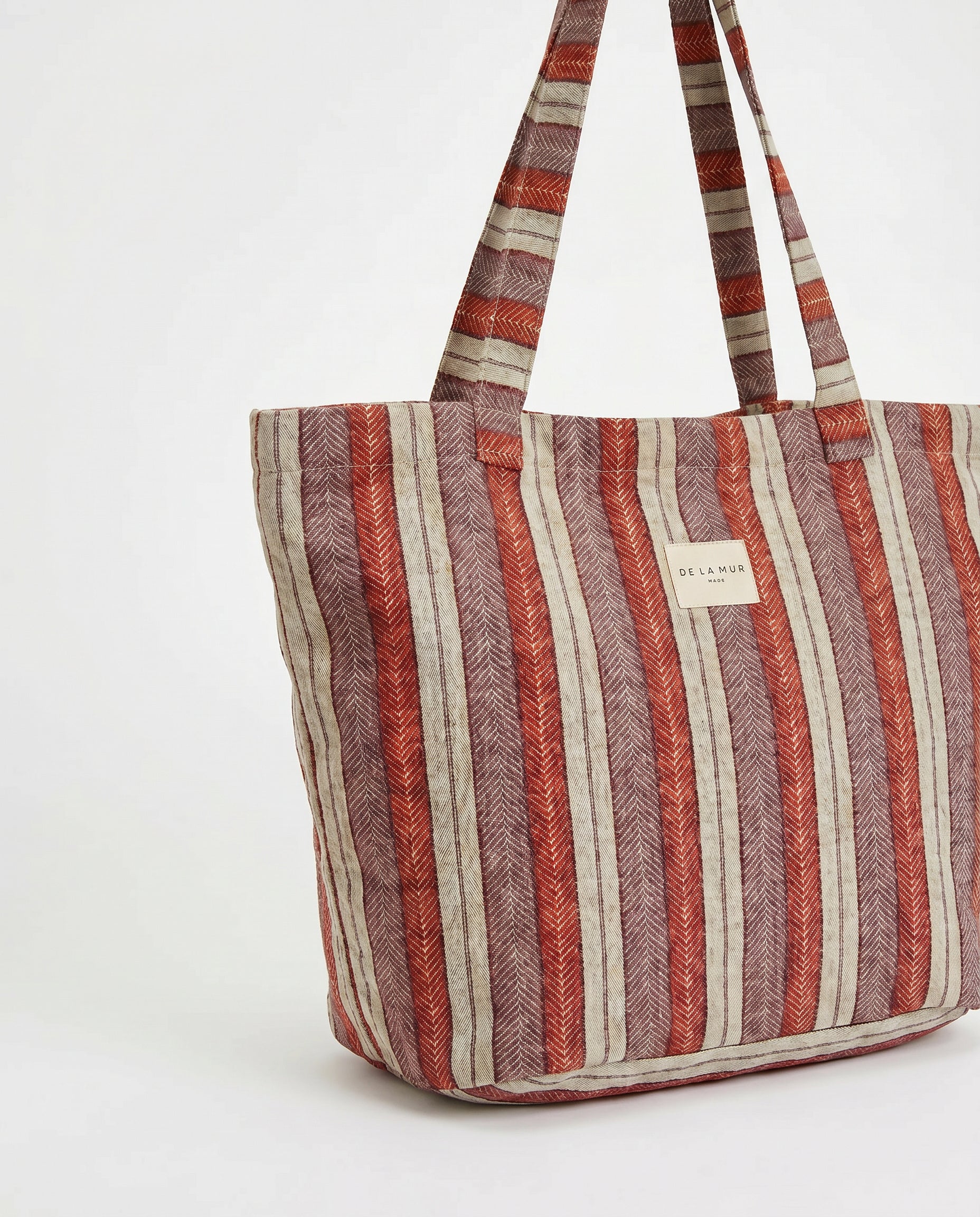 Bolsa shopper de jacquard con estampado de rayas en tonos rojo, lila y crudo, vista frontal.