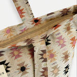 Detalle del tejido jacquard y las asas de la bolsa tote.
