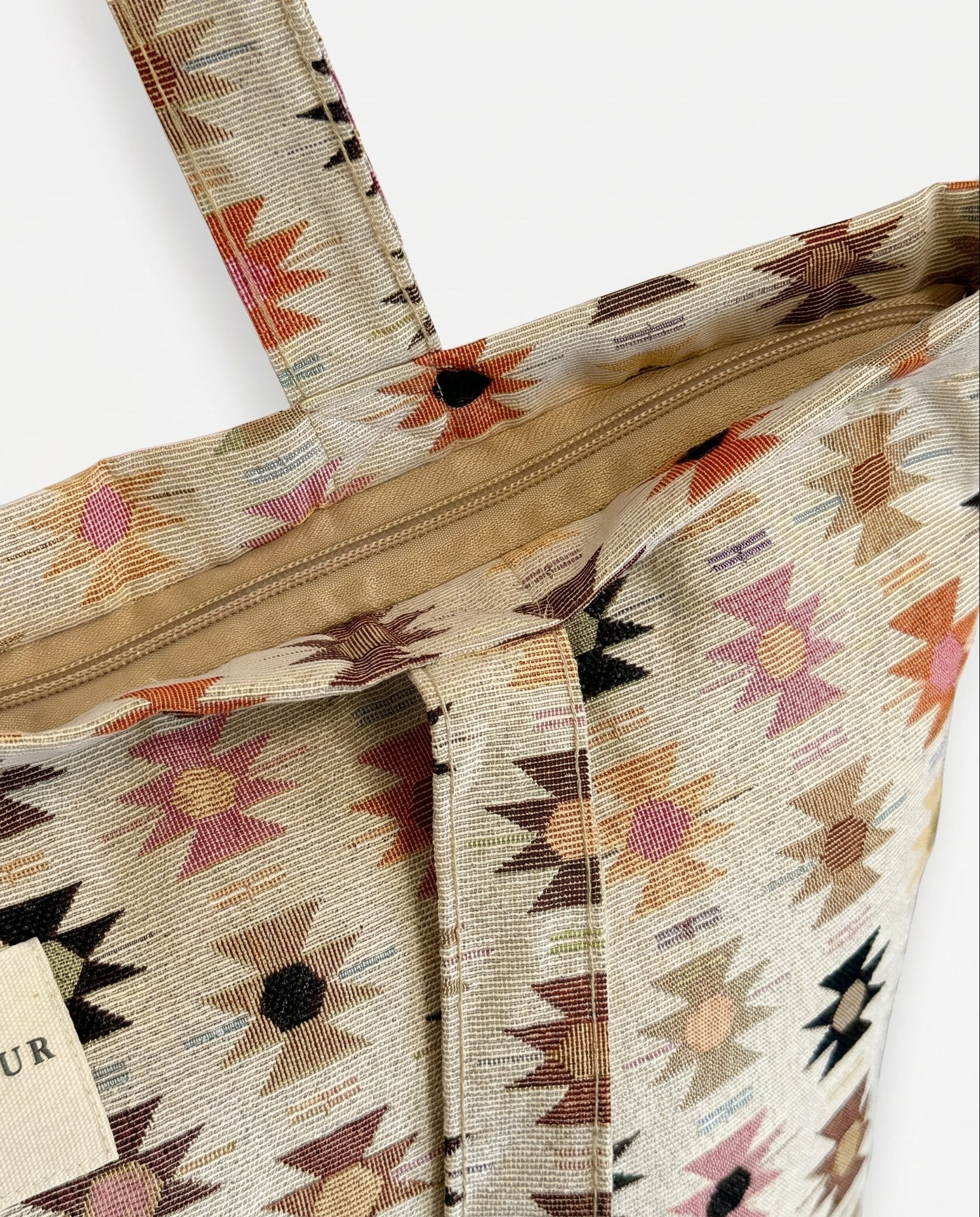 Detalle del tejido jacquard y las asas de la bolsa tote.
