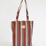 Vista frontal de la bolsa tote de jacquard con estampado de rayas.