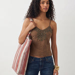 Bolsa tote de jacquard de rayas colgada al hombro.