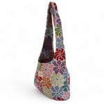 Vista lateral de la bolsa floral con asas anchas y fondo blanco.