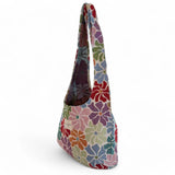 Vista lateral de la bolsa floral con asas anchas y fondo blanco.