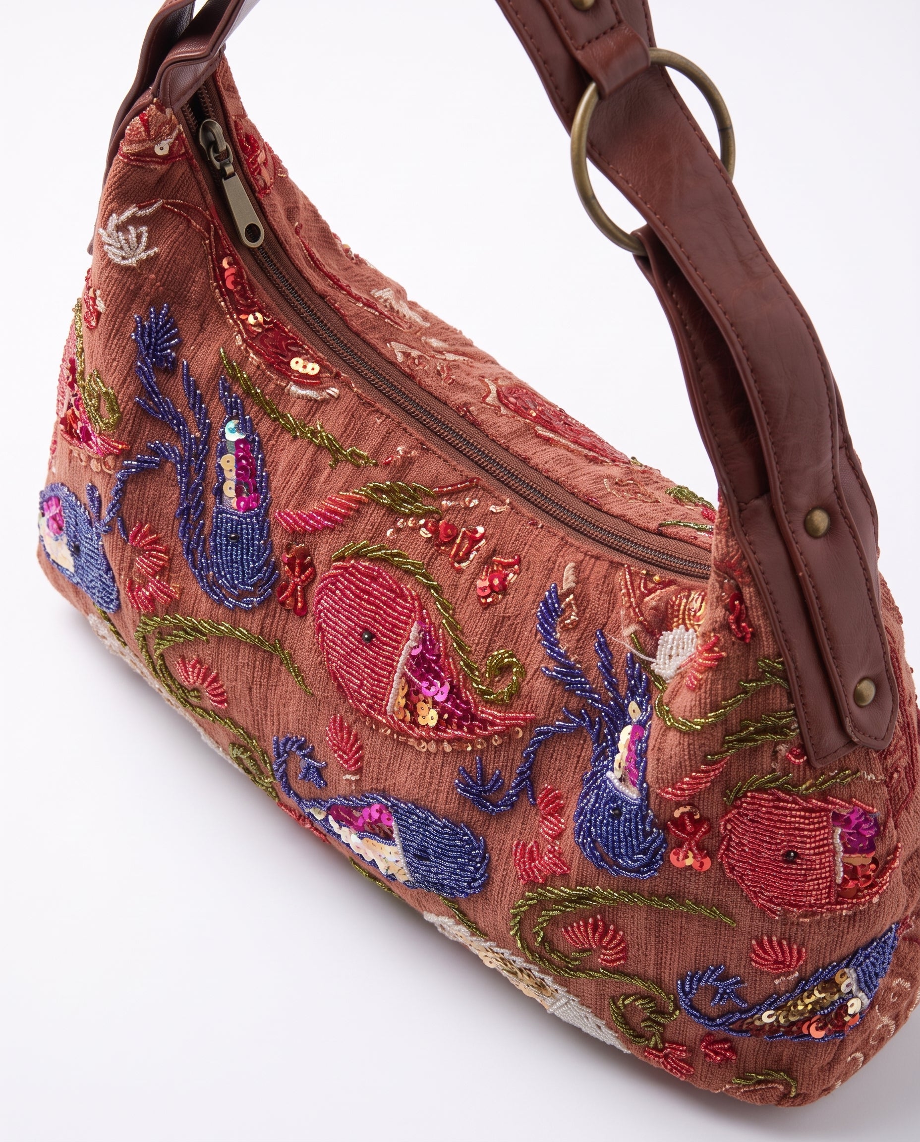 Vista lateral del bolso hobo vintage con bordados de peces y detalles de lentejuelas.