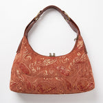 Parte trasera del bolso hobo vintage con estampado en relieve y asa regulable.