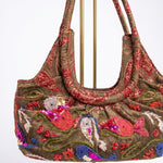 Vista en perspectiva del bolso vintage con bordados marinos y detalles de lentejuelas.