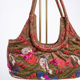 Vista en perspectiva del bolso vintage con bordados marinos y detalles de lentejuelas.