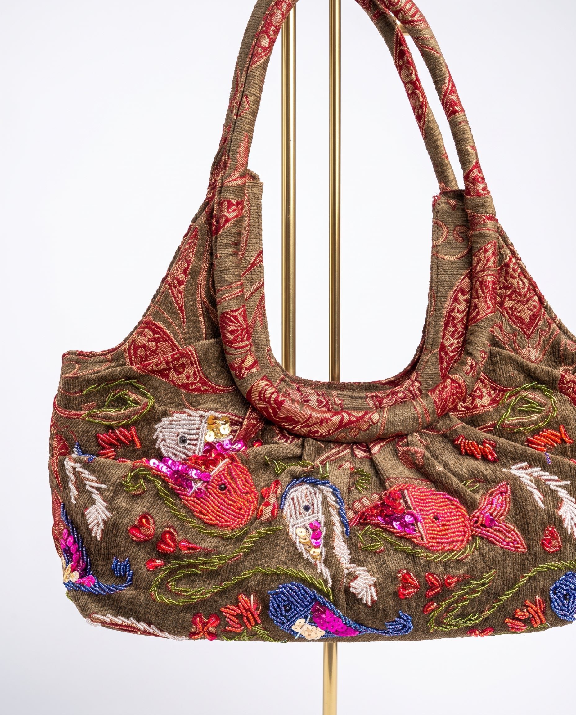 Vista en perspectiva del bolso vintage con bordados marinos y detalles de lentejuelas.