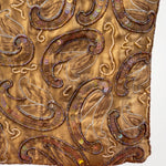 Imagen 3: Detalle del estampado cachemir con bordados y abalorios sobre tejido dorado.