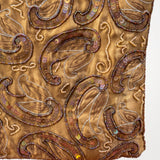 Imagen 3: Detalle del estampado cachemir con bordados y abalorios sobre tejido dorado.