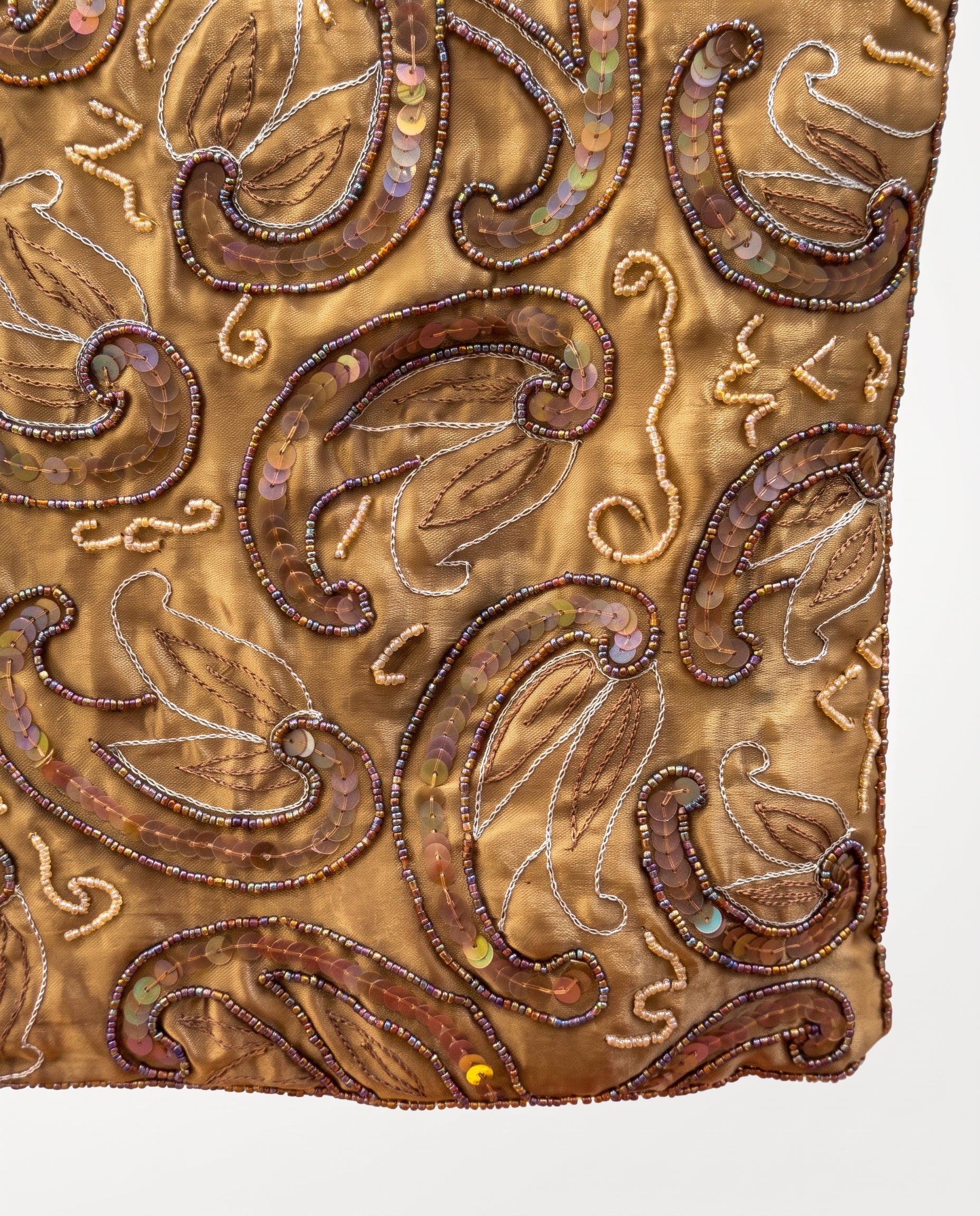 Imagen 3: Detalle del estampado cachemir con bordados y abalorios sobre tejido dorado.