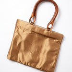 Imagen 2: Vista trasera del bolso vintage dorado con asas de madera.