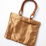 Imagen 2: Vista trasera del bolso vintage dorado con asas de madera.