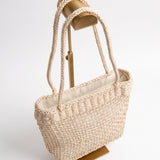 Vista lateral del bolso vintage de fibra trenzada color crema.