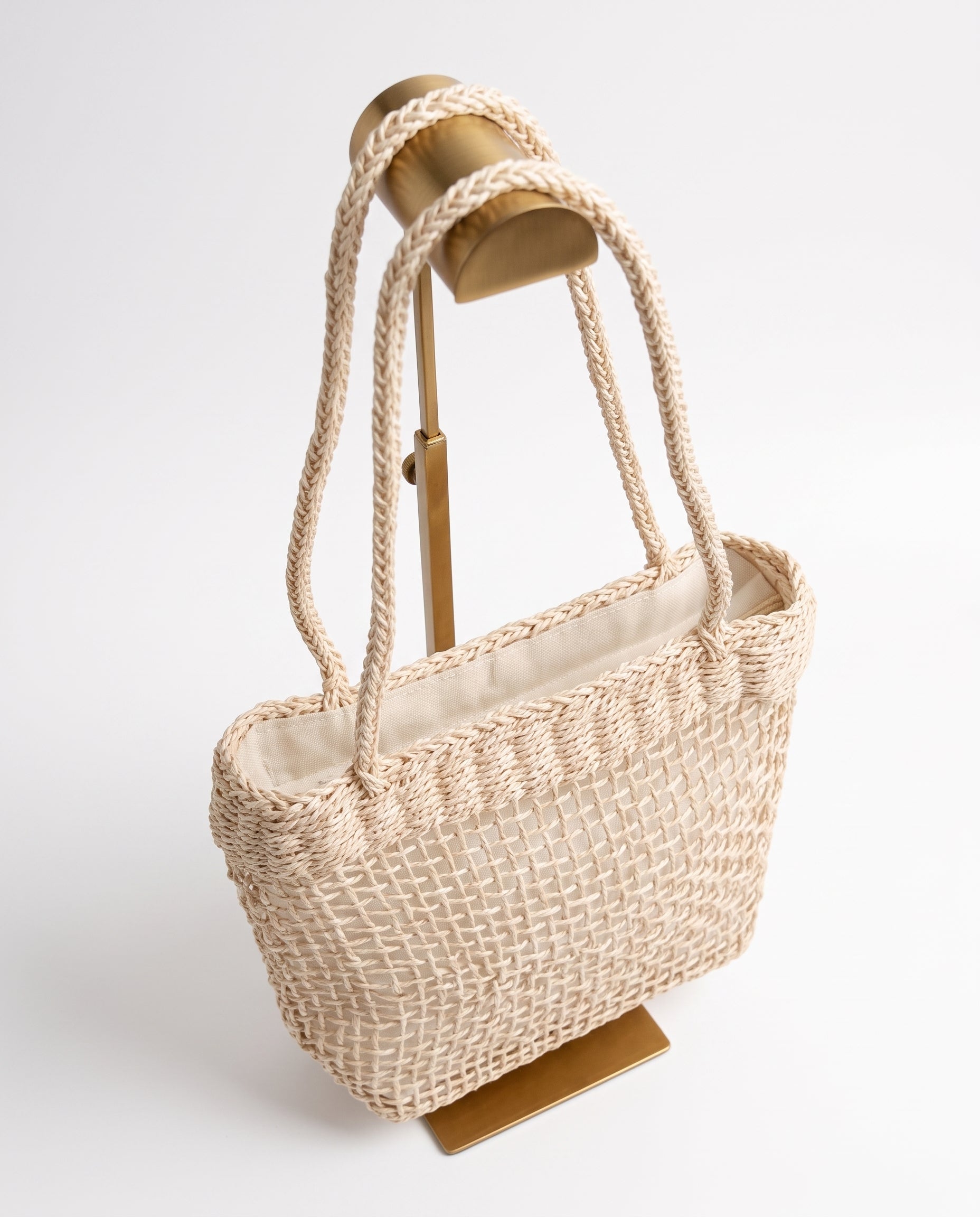 Vista lateral del bolso vintage de fibra trenzada color crema.